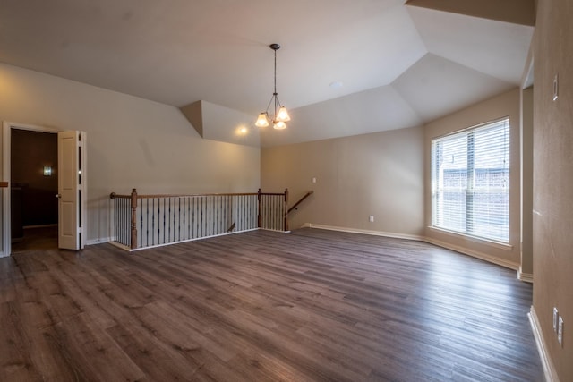 unfurnished living room featuring lofted ceiling, an inviting chandelier, and dark wood-type flooring