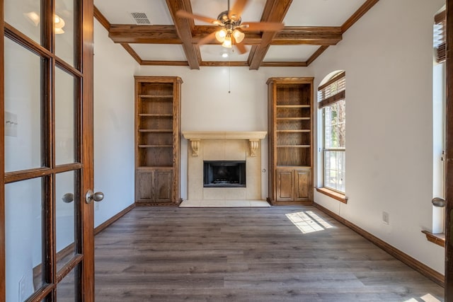 unfurnished living room featuring ceiling fan, coffered ceiling, beamed ceiling, crown molding, and hardwood / wood-style floors