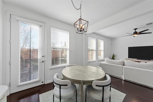 dining room featuring ceiling fan with notable chandelier and dark wood-type flooring