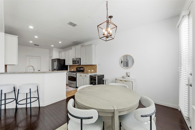 dining area featuring hardwood / wood-style flooring and a chandelier