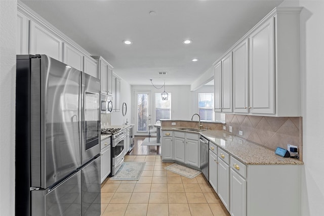 kitchen featuring white cabinets, pendant lighting, stainless steel appliances, and sink