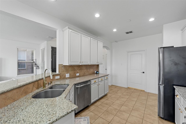 kitchen with light stone counters, white cabinetry, sink, and appliances with stainless steel finishes