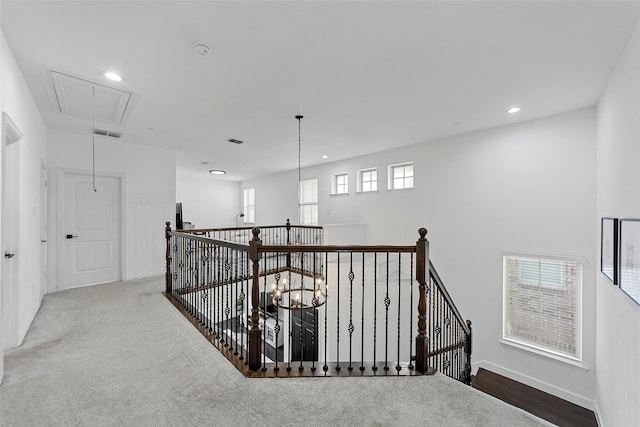 hallway with carpet and a chandelier