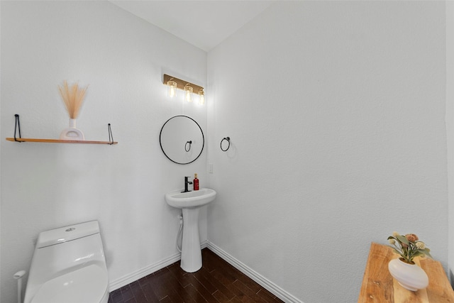 bathroom with wood-type flooring, vaulted ceiling, and toilet