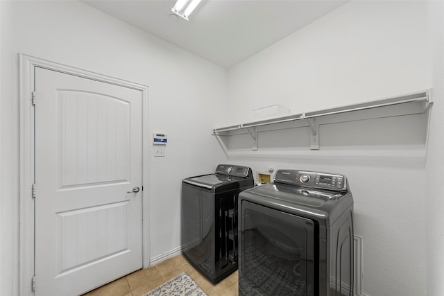 washroom with light tile patterned flooring and washing machine and clothes dryer