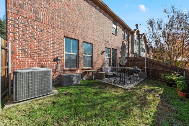 rear view of property featuring a yard, a patio, and central AC unit