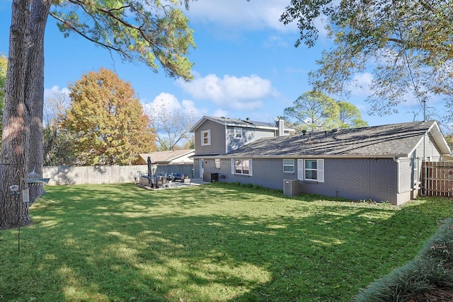 view of yard with central AC and a patio