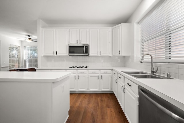 kitchen with white cabinetry, sink, decorative backsplash, stainless steel appliances, and dark wood-type flooring