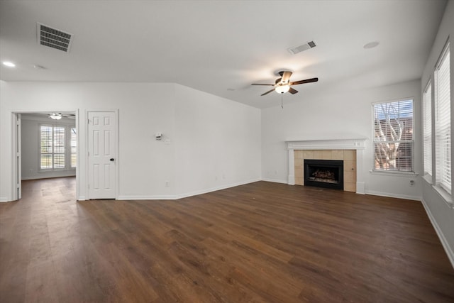 unfurnished living room featuring dark wood-type flooring, ceiling fan, and a fireplace