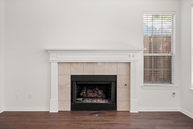 room details featuring wood-type flooring and a tiled fireplace