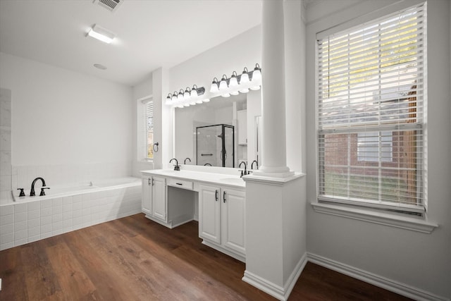 bathroom with ornate columns, wood-type flooring, independent shower and bath, and vanity