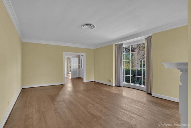 empty room featuring ornamental molding and hardwood / wood-style floors