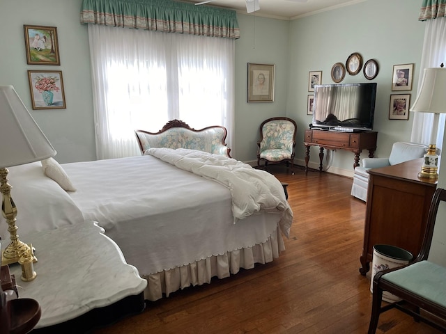 bedroom with dark wood-type flooring and ornamental molding