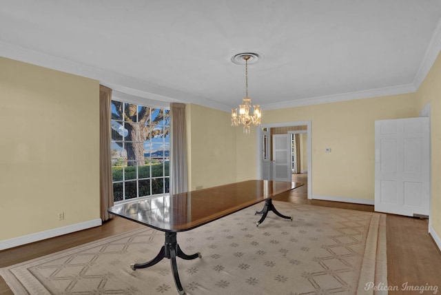 unfurnished dining area featuring crown molding, hardwood / wood-style floors, and a notable chandelier