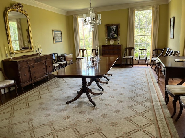 dining space featuring ornamental molding, wood-type flooring, and a chandelier