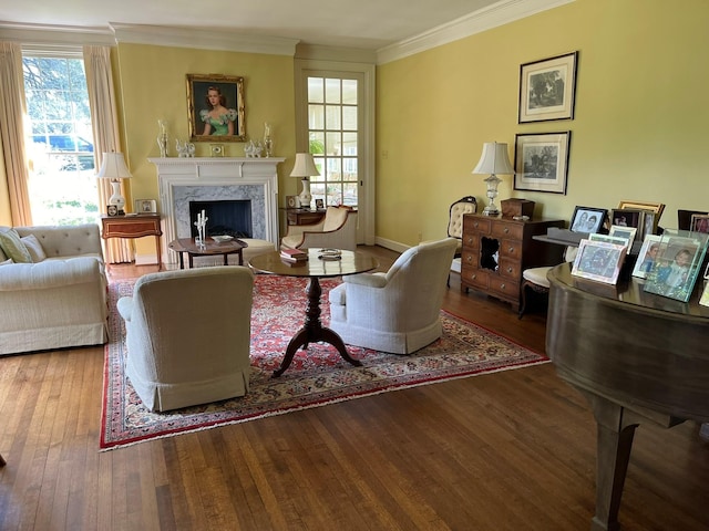 living room with a high end fireplace, wood-type flooring, and ornamental molding