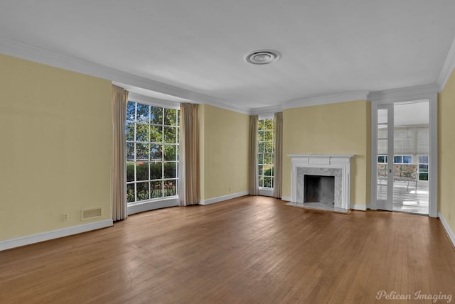 unfurnished living room with crown molding, a high end fireplace, and light wood-type flooring