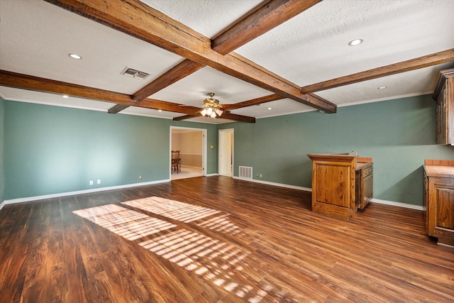 interior space with visible vents, baseboards, wood finished floors, and beamed ceiling