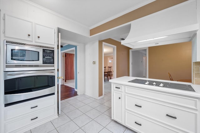 kitchen featuring white cabinetry, light tile patterned floors, ornamental molding, and stainless steel appliances