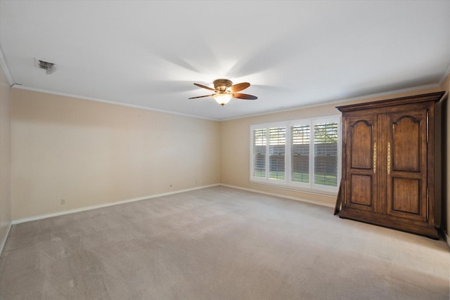 unfurnished bedroom with crown molding, light carpet, and ceiling fan