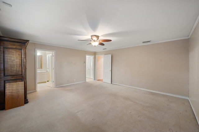 empty room featuring light carpet, crown molding, and ceiling fan