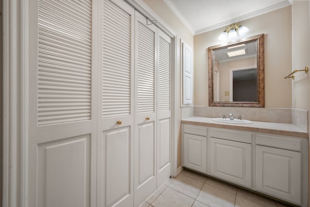 bathroom featuring crown molding, vanity, tile patterned flooring, and a closet