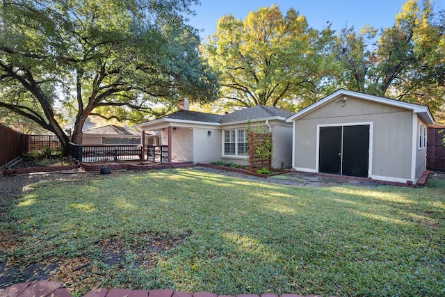 back of house with a yard and an outbuilding