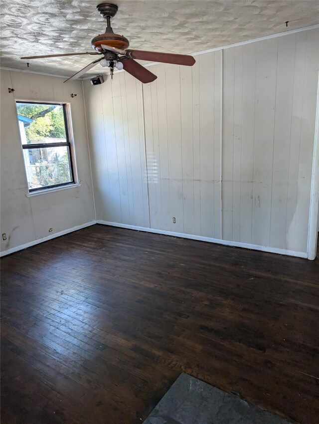 spare room featuring dark wood-type flooring and wood walls