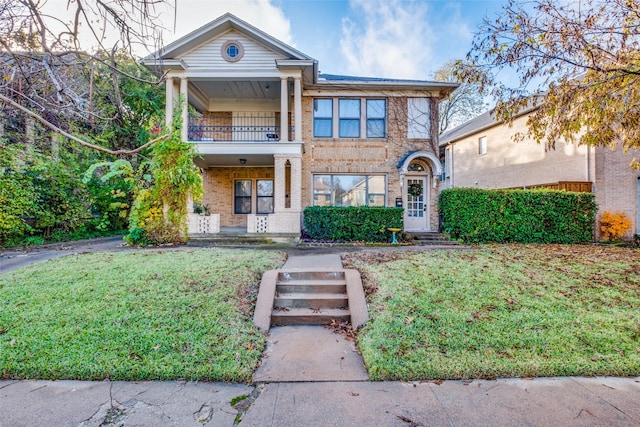 view of front of home featuring a balcony and a front yard