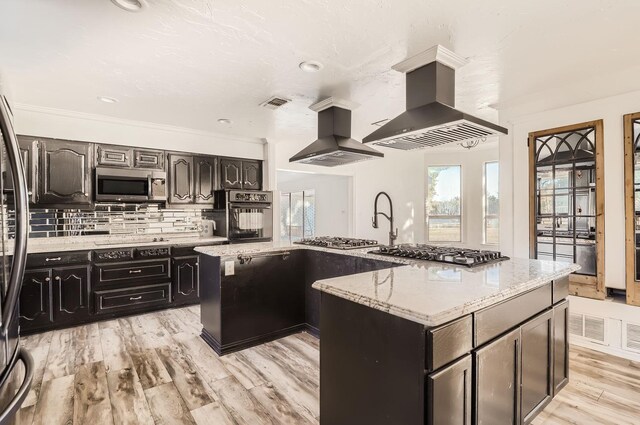 kitchen featuring black appliances, island range hood, an island with sink, and extractor fan