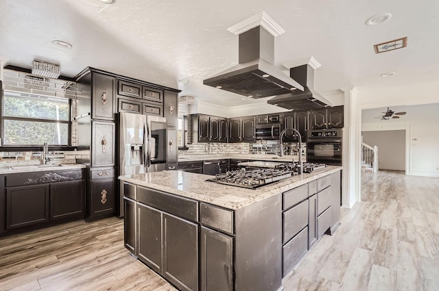 kitchen with island exhaust hood, a center island, stainless steel appliances, and light hardwood / wood-style flooring