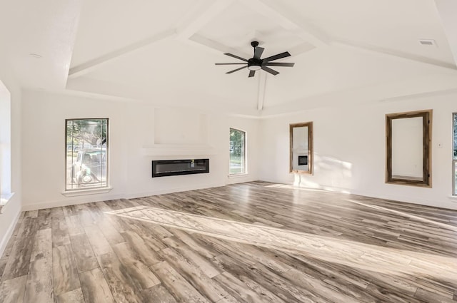 unfurnished living room with ceiling fan, beamed ceiling, wood-type flooring, and high vaulted ceiling