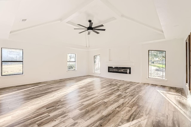 unfurnished living room with ceiling fan, beam ceiling, light wood-type flooring, and high vaulted ceiling