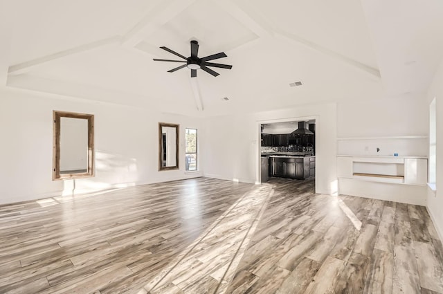 unfurnished living room with beam ceiling, hardwood / wood-style flooring, high vaulted ceiling, and ceiling fan