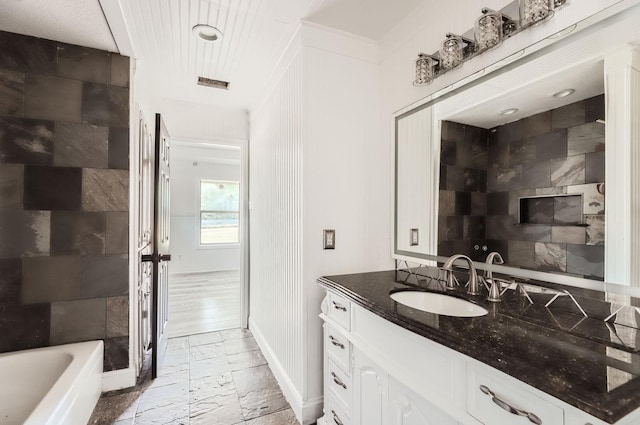 bathroom featuring vanity and a tub to relax in