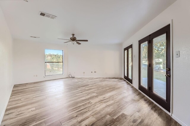 spare room with ceiling fan, light hardwood / wood-style floors, and a wealth of natural light