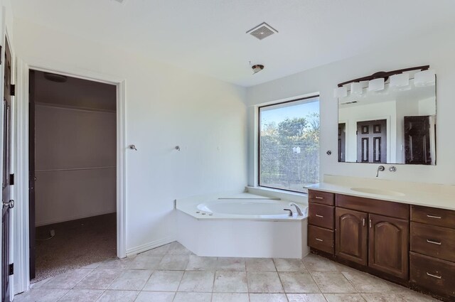 bathroom featuring tile patterned flooring, vanity, and a tub