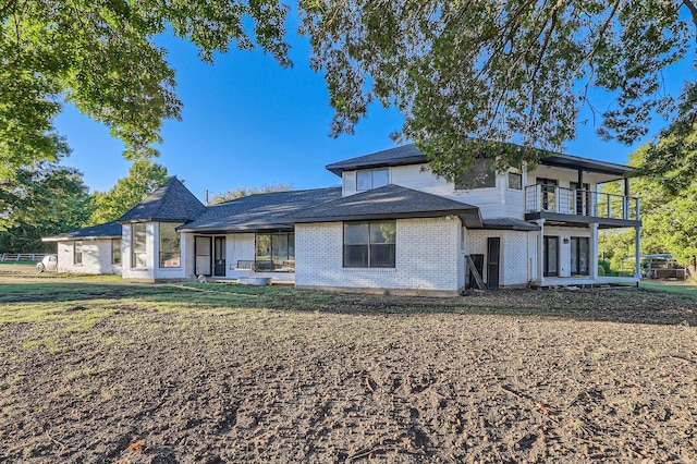 view of front of home with a balcony, a front lawn, and a patio area