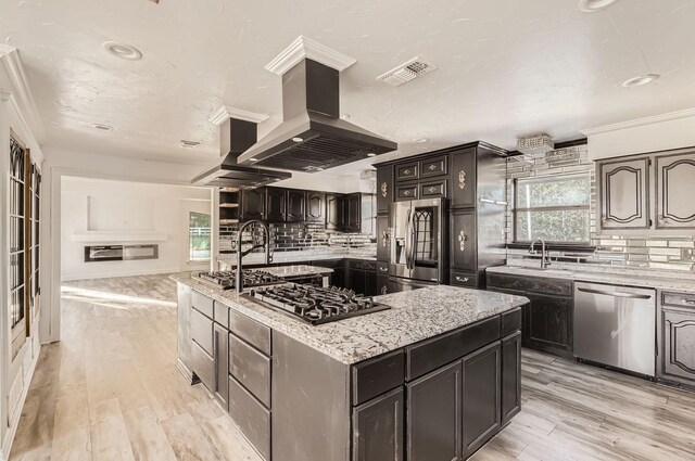 kitchen featuring light hardwood / wood-style floors, decorative backsplash, a kitchen island, island range hood, and appliances with stainless steel finishes