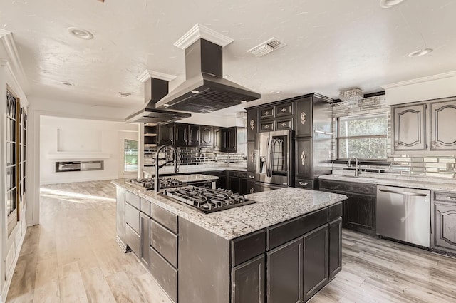 kitchen featuring decorative backsplash, island exhaust hood, a center island, and appliances with stainless steel finishes