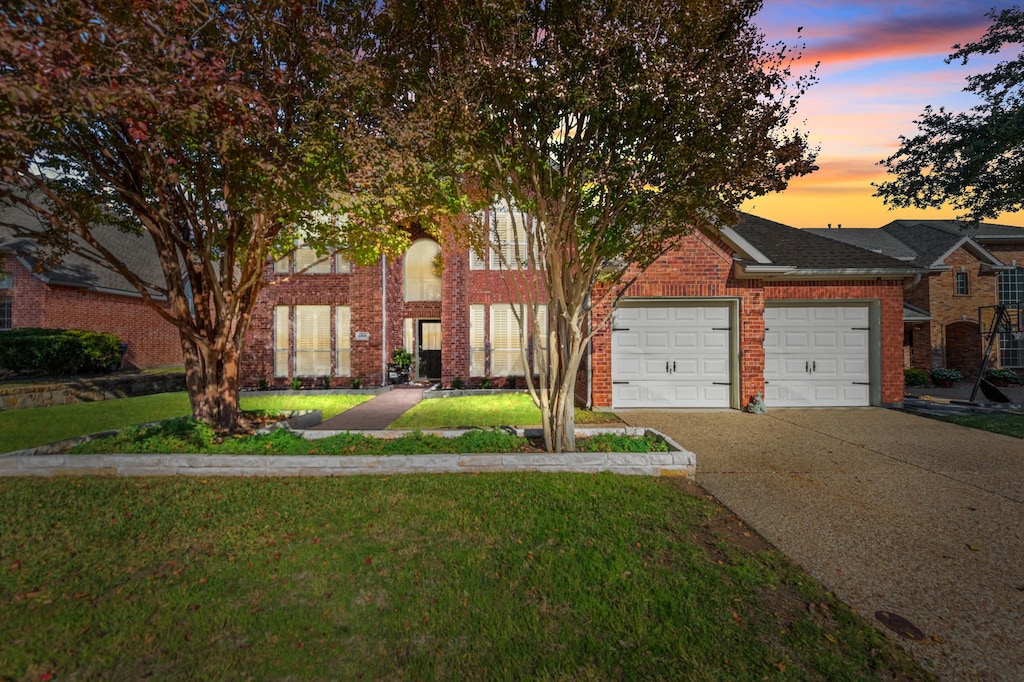 view of front of property with a garage and a yard