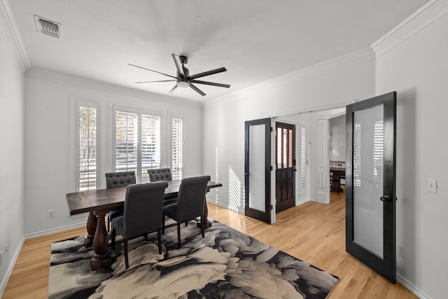 dining area with crown molding, light hardwood / wood-style flooring, french doors, and ceiling fan