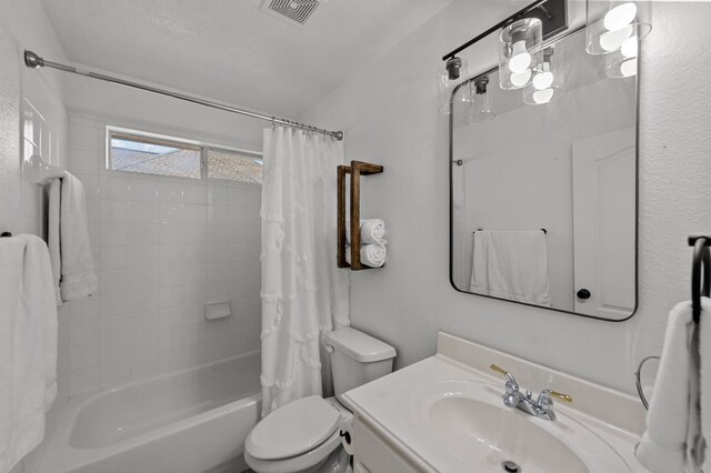 full bathroom with vanity, shower / bathtub combination with curtain, and toilet