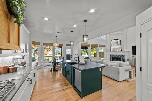 kitchen with appliances with stainless steel finishes, sink, a center island with sink, and white cabinets