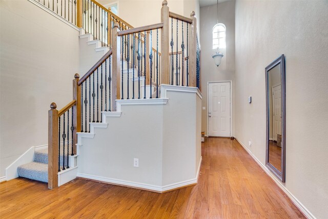 stairway with a high ceiling and hardwood / wood-style flooring