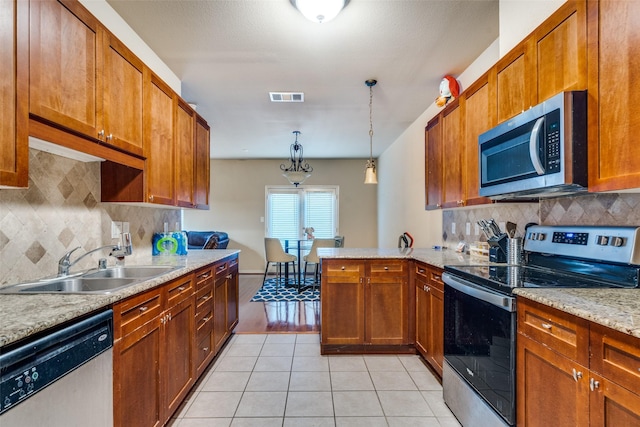 341 Metropolitan Dr, Plano, TX 75023 - kitchen featuring stainless steel appliances, a peninsula, backsplash, and light tile patterned floors