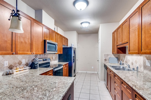 341 Metropolitan Dr, Plano, TX 75023 - kitchen with stainless steel appliances, backsplash, light tile patterned floors, brown cabinetry, and light stone counters