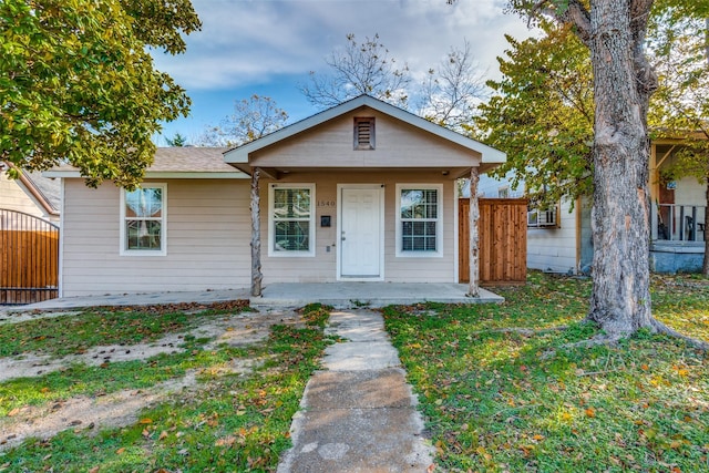 bungalow with a front lawn and covered porch