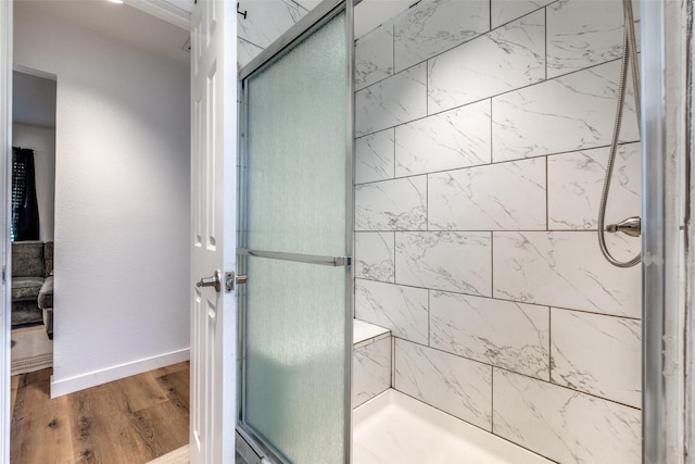 bathroom with hardwood / wood-style flooring and walk in shower