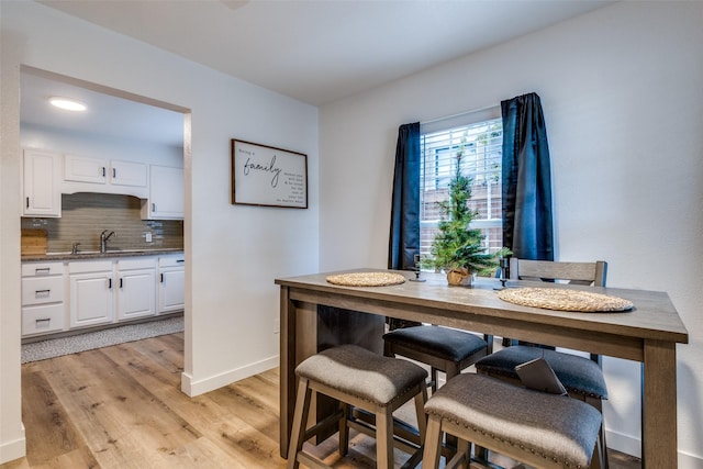 dining area with sink and light wood-type flooring